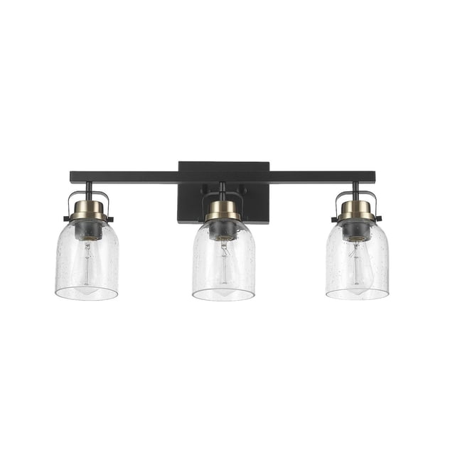 Rockhampton 3-Light Vanity Light with matte black rectangular backplate and horizontal bar, three clear seeded glass shades with matte brass accent sockets, suitable for bathroom or kitchen wall mounting and compatible with E26 bulbs.