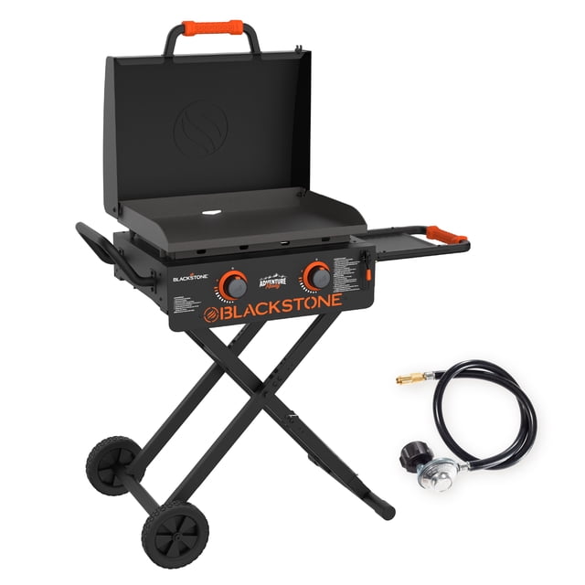 Blackstone Adventure Ready 2-Burner 22" Propane Omnivore Griddle with Flexfold Legs shown open with a matte black rolled-steel griddle plate featuring built-in wind guards and two orange heat-control knobs. It stands on collapsible X-shaped legs with wheels and orange non-slip handle grips on the lid and side shelf. Includes a propane hose with regulator and 20 lb tank adapter for extended use.