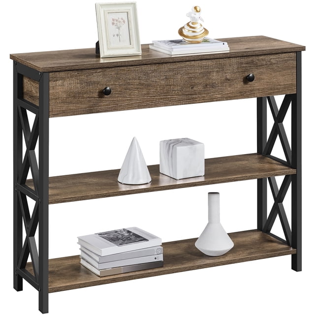 Yaheetech 2-Tier X-Design Console Table for Entryway Living Room in taupe wood finish. The table features a rectangular top, a spacious drawer with black round knobs, and two open shelves supported by black iron X-design side panels. Decorative items such as books, vases, and photo frames are displayed on the table. Dimensions are 39.5x12x32 inches, with a top load capacity of 198 lbs, middle shelf capacity of 55 lbs, and drawer capacity of 22 lbs.