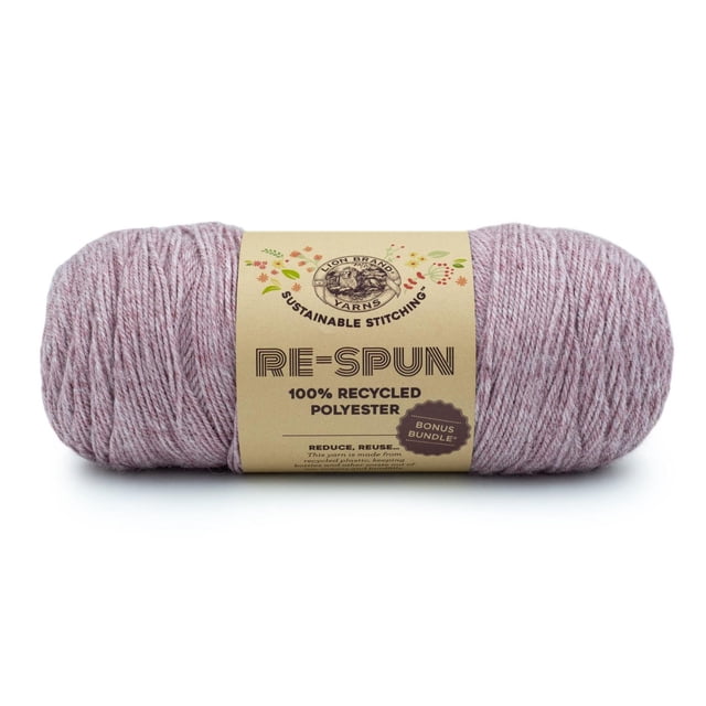 Lion Brand Re-Spun Bonus Bundle Yarn in blush, a 284-gram skein of 100% recycled polyester worsted weight yarn with a soft texture, wrapped in a beige label featuring the Lion Brand logo and sustainable stitching text, ideal for eco-friendly knitting, crocheting, and crafting projects including garments and home décor.