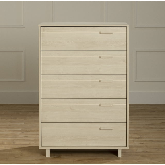 South Shore Noah 5-Drawer Chest for Child in bleached oak with five drawers featuring wood handles and metal glides, standing on short legs on a hardwood floor against a beige paneled wall, suitable for kids' furniture and room organization.