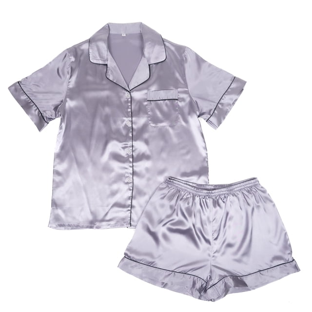 Women’s Short Sleeve Button Down Silky Satin Pajamas For Adults - 2 Piece Shorts Set, Sizes Small To X-Large. This set includes a short-sleeve button-down top with a chest pocket and matching elastic-waist shorts, both crafted from luxurious satin in a light lavender hue. The fabric features a smooth, glossy finish for ultimate comfort and elegance, suitable for sleepwear or lounging.