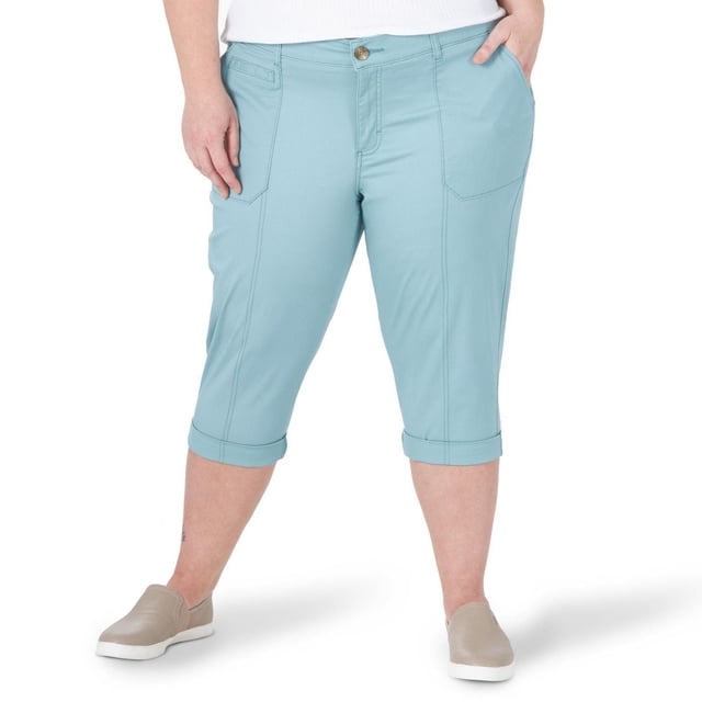 Lee Riders Women's Plus Comfort Waist Utility Capri in light blue with a comfort waist featuring hidden elastic, button and zipper closure, front patch pockets, and back welt pockets, cropped below the knee with cuffed hems, suitable for casual wear and outdoor activities.