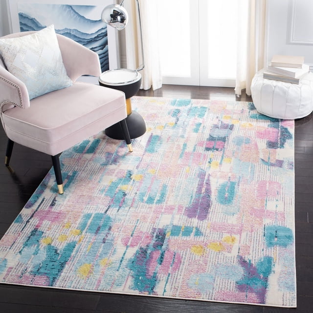Safavieh Lillian Alisa Tapis Floral Brossé à Poils Courts Présentant un Motif Floral Aquarelle dans des Tons Rose pastel, Bleu, Violet et Jaune sur des Planchers de Bois Franc Sombres. le Tapis Se Tient Partiellement sous une Chaise d'Appoint Rose blush avec des Pattes Noires à Pointes Dorées, à Côté d'Une table d'Appoint Noire et Dorée avec une Lampe Chromée, et un pouf Blanc avec des Livres Près de Voilages, Ajoutant une Touche Artistique Douce à la Pièce.