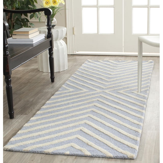 Safavieh Cambridge Lilly Tapis à Rayures en Losanges avec texture de Laine Tuftée à la Main et Motif à Rayures en Losanges Bleu et Crème, Posé sur un Plancher de Bois Clair entre un Banc en Bois Noir et une Chaise Blanche Près d'Une Porte Blanche à Panneaux de Verre, Idéal pour Ajouter un style Moderne et du Confort aux Entrées Ou aux Couloirs.
