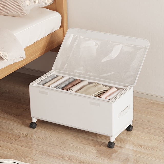 TopLLC under bed storage container with wheels, featuring a white cloth exterior, metal frame, and clear PVC lid. The container measures 22.4 x 11.8 x 11.4 inches and is shown partially open, revealing neatly folded clothes inside. Designed for multi-purpose use, it includes 360-degree rolling wheels for easy mobility and is ideal for storing shoes, clothes, and other items under the bed. Suitable as a storage basket or organizer, it is positioned on a wooden floor next to a bed frame.
