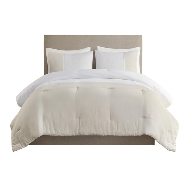 Beautyrest Mika 3 Piece Gauze Oversized Comforter Set on a beige upholstered bed, featuring a lightweight, natural two-tone gauze comforter in neutral shades with matching standard shams, designed for a casual and elegant bedroom style, also suitable for layering with other bedding pieces.