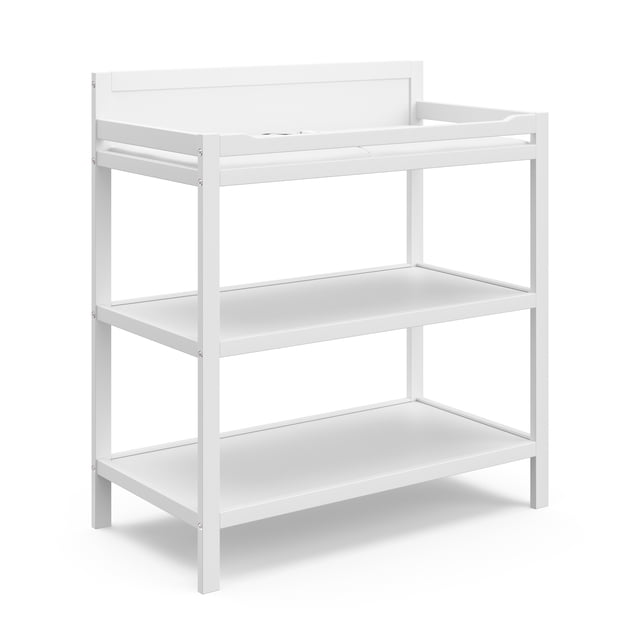 Storkcraft Alpine Table à Langer Blanche avec Deux Étagères de Rangement Ouvertes et une Surface de Matelas à Langer Résistante à l'Eau avec Rampes de Sécurité, Fabriquée en Pin et Bois d'Ingénierie, Vérifiée par la Baby safety Alliance et Certifiée GREENGUARD Gold, Montrée en Vue avant 3/4.