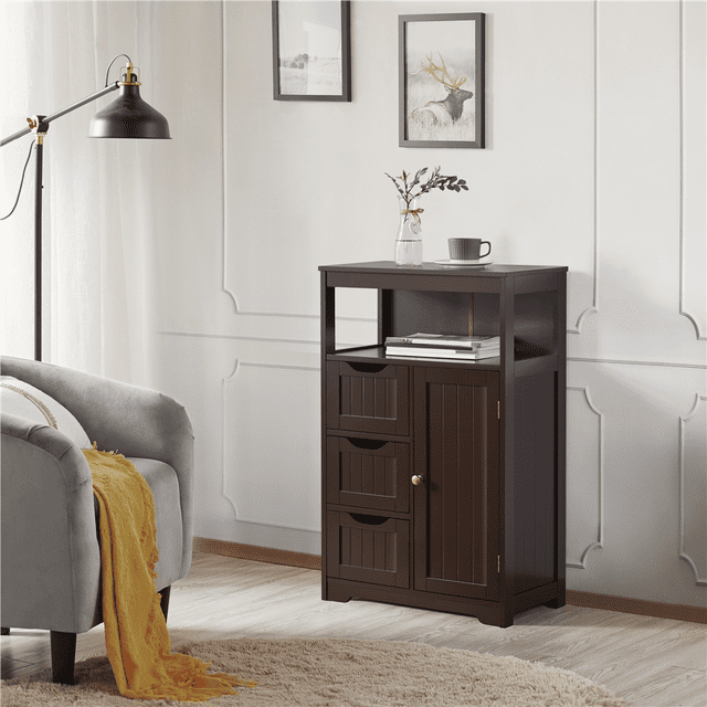 Yaheetech Freestanding Bathroom Floor Cabinet with Drawers in espresso finish, featuring a rectangular design with clean lines. The cabinet includes a tabletop, an open shelf, three drawers, and a small two-tier cabinet with an adjustable shelf. Made of durable MDF boards with metal accessories, it is shown in a modern living room setting with a grey armchair, a yellow throw blanket, and wall decor. Dimensions are 22 x 12 x 34 inches.