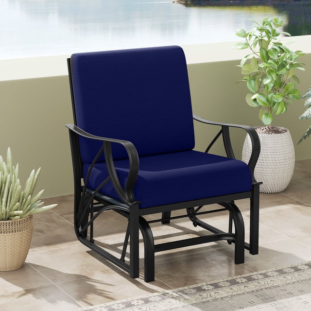 Gymax Patio Glider Chair Single Outdoor Rocking Chair with seat and back cushions in navy. Features a heavy-duty metal frame with a weight capacity of 330 lbs, ergonomic backrest, and curved armrests. The chair includes removable zippered cushion covers for easy cleaning and hook and loop fasteners to keep cushions in place. Designed with a smooth gliding mechanism for noiseless rocking. Shown on a tiled patio with plants and a view of water in the background.