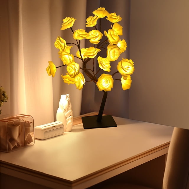 TIMIFIS Rose Tree Lamp, a 1.5ft tall artificial flower night light with LED rose-shaped branches, displayed on a desk in a softly lit bedroom. The lamp features adjustable branches and a USB connection, making it suitable for home decor, festive occasions, or as a unique gift. The black base provides stability, and the warm yellow glow of the roses creates a cozy ambiance.