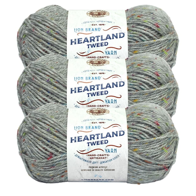 Lion Brand Yarn Heartland Yarn 3Pack showing three skeins of medium worsted weight acrylic tweed yarn in light grey with multicolored flecks, each wrapped with a label featuring Heartland Tweed branding, suitable for knitting, crochet, and textured craft projects.