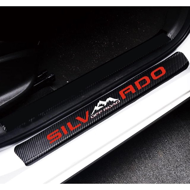 GHSDFBB 4Pcs Car Door Sill Protector Reflective 4D Carbon Fiber Sticker Decoration Door Entry Guard Door Sill Scuff Plate Stickers compatible with Silverado Off Road in red. The image shows a close-up of a car door sill with a black carbon fiber texture and red reflective text reading 'SILVERADO Off Road' alongside a mountain graphic. Designed to protect the car door plate from scratches and wear, the protector is waterproof, anti-scratch, and easy to clean. Includes four pieces for front and back doors and a small plastic scraper for installation.