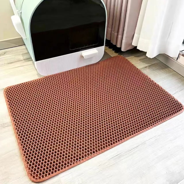 LSLJS Double-layer EVA Non-slip Litter Mat for pet litter boxes, featuring a honeycomb pattern for litter filtration and control. The mat, in a warm brown tone, is rectangular with a textured surface, placed on a light wood floor near a cat litter box. Designed to protect floors from stains, it includes a non-slip backing for stability and fits all litter box sizes.