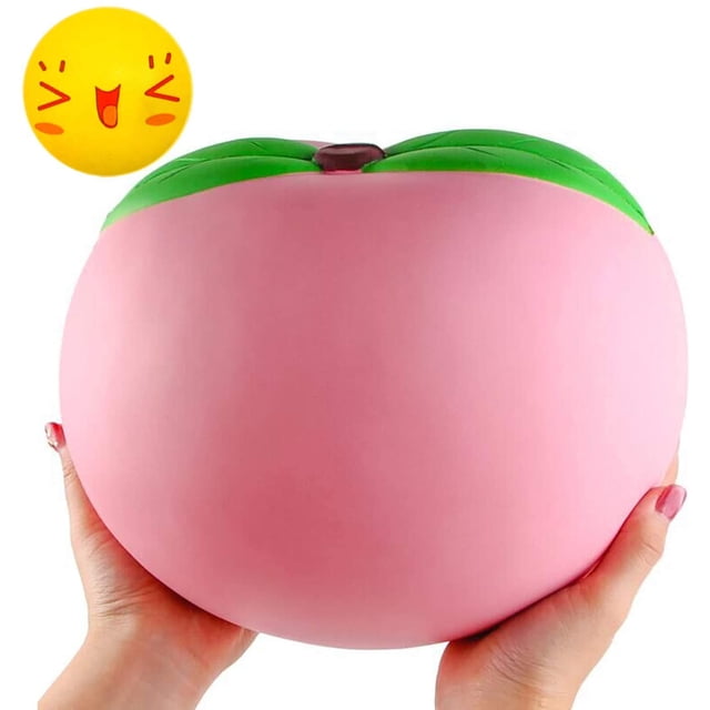 10 inch Jumbo Squishies, large pink peach squishy novelty toy with green leaf detail, held in hands. Made of soft polyurethane foam, slow rising and cream scented. Includes one random mini toy. Suitable for stress relief, birthday gifts, and decorative props.