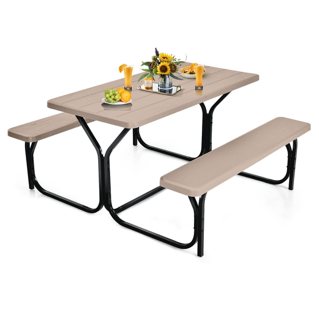 Gymax Picnic Table Camping Picnic Bench Set with a wood-like textured tabletop and benches crafted from high-density polyethylene in a neutral tone. Designed for outdoor use, it features a UV-protected, rust-resistant, powder-coated steel frame. The table is styled with sunflowers, fruit, and beverages, highlighting its suitability for patio dining, backyard parties, or garden picnics.