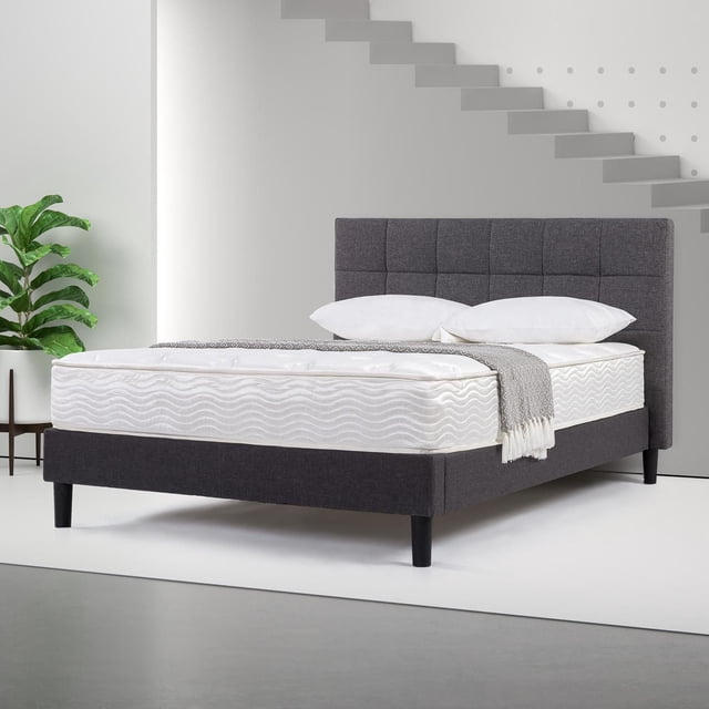Zinus Spa Sensations Matelas à Ressorts de 10 Pouces avec Mousse Haute Densité et Ressorts Ensachés en Acier sur un Cadre de Lit Rembourré Gris Foncé avec Tête de Lit Capitonnée, Habillé de Coussins Blancs et d'Un Jeté Gris dans une Pièce Minimaliste avec une Plante en Pot et un Escalier.