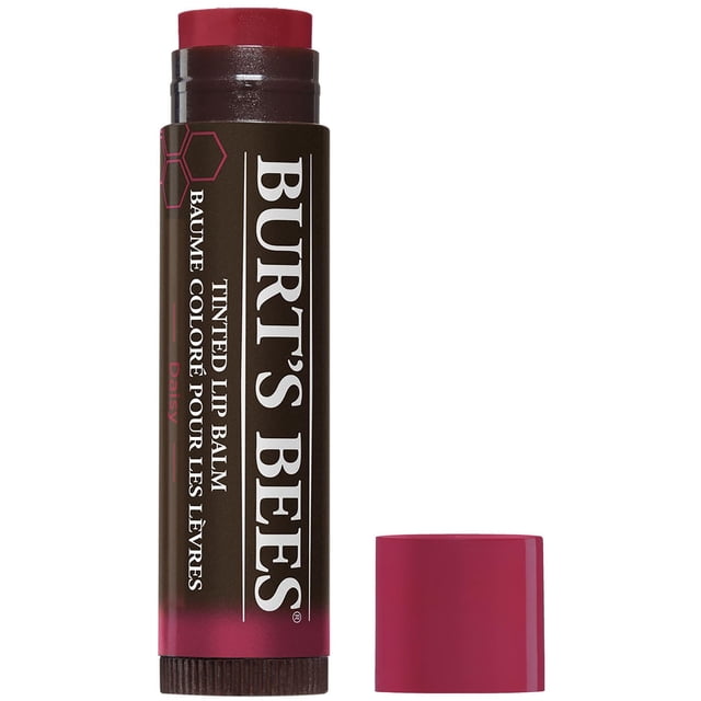 Burt’s Bees® 100% Natural Origin Moisturizing Tinted Lip Balm, Daisy with Shea Butter in an open dark brown tube with white text and pink hexagon accents, showing a warm neutral plum tinted balm and matching pink cap beside it, suitable for hydrating lips with a sheer natural tint