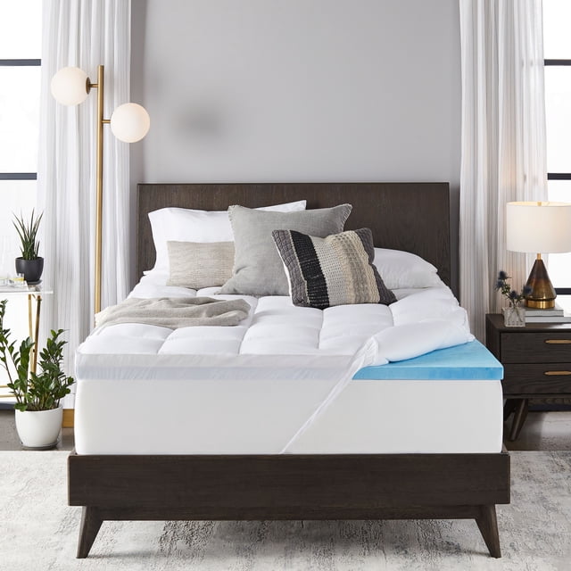 Sleep Innovations 4-inch Dual Layer Gel Memory Foam Mattress Topper, King, Enhanced Support displayed on a modern bed in a bright bedroom. The topper features a quilted top layer and a blue gel memory foam layer, offering enhanced comfort and support. Ideal as a luxury bedding accessory.