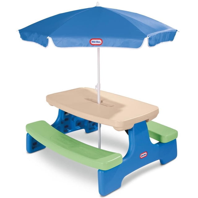 Little Tikes Easy Store Picnic Table with Umbrella in blue and green featuring a beige tabletop, blue frame, and green benches. This portable kids' outdoor furniture seats six children, includes two cup holders, a condiment tray, and a blue umbrella with the Little Tikes logo. It folds easily for indoor or outdoor use.