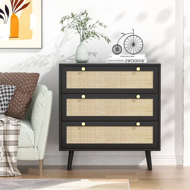 Eumyviv Commode Noire à 3 Tiroirs avec Pattes en Bois de Pin, Commode de Style Ferme en Rotin, Armoire de Rangement H0075. une Commode Noire de Style Ferme avec Trois Tiroirs Spacieux Comprenant des Panneaux en Rotin Faits à la Main Naturels et des Poignées en Métal Doré. Idéale pour les solutions de Rangement de Meubles de Chambre Ou de Salon, l'Armoire Est Soutenue par des Pattes en Bois de Pin Durables et Exposée dans un Cadre Moderne avec des accents Décoratifs comme un vase, des Livres et une sculpture de Bicyclette sur le Dessus.