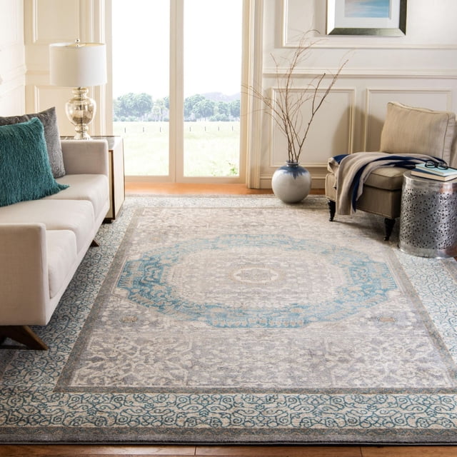 Safavieh Sofia Waylon Tapis à Bordure Géométrique Présentant des motifs Traditionnels et une Patine à l'Allure Usée dans des Tons Bleu et Gris, Posé sur un Plancher de Bois Franc dans un Salon Lumineux entre un sofa beige avec des Coussins Sarcelle et Gris et un Fauteuil beige avec une table d'Appoint et de Jeté, Convenant à Rehausser la Déco Classique de la Maison avec un style durable.
