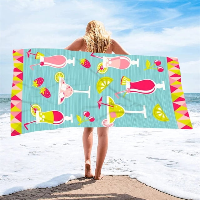 Microfiber lightweight beach towel with a colorful cocktail and fruit pattern, measuring 27x59 inches. Designed for sand-free, quick-dry, and absorbent use, ideal for swimming pools, camping, and beach trips. The towel is shown held by a person on a sunny beach with waves in the background.
