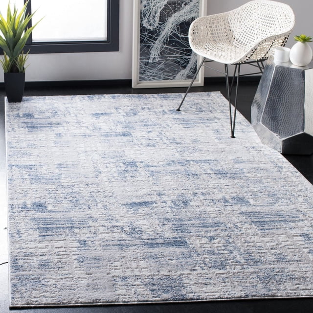 Safavieh Amelia Carrie Abstract Distressed Area Rug featuring a plush synthetic yarn texture with a blue and grey abstract pattern, placed on a dark floor beside a white woven chair and a hammered metal side table with small plants, suitable for modern living rooms or bedrooms.