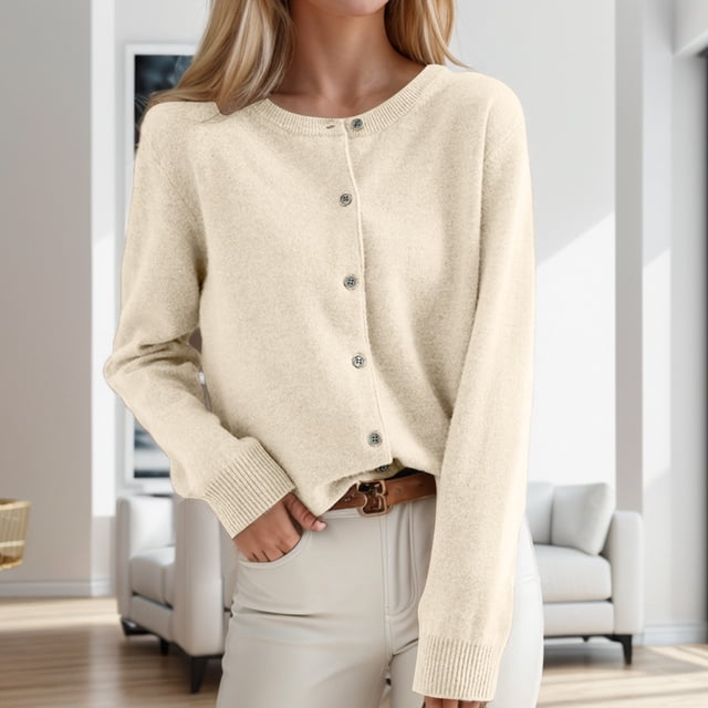 Classic Women's Cardigan Sweater with an open front and crew neck button design, crafted from polyester knit fabric in a neutral beige tone. Ideal for casual wear or layering, this cardigan transitions seamlessly from daily outings to sophisticated events. The model is pictured in a modern indoor space with light-colored furniture.