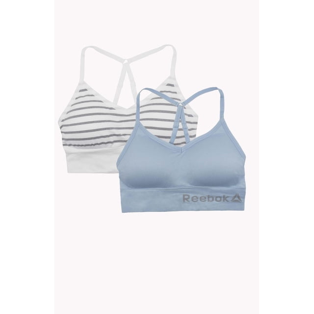 Reebok Ladies' 2 Pack Seamless Longline Bralettes including one light blue bralette with adjustable straps and Reebok logo on the band, and one white bralette with grey stripes and racerback design, both seamless with stretch fabric for smooth fit and optimal movement, ideal for yoga, training, or casual wear.