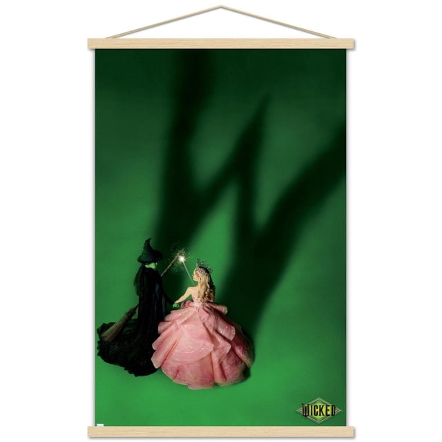 Wicked - Affiche Murale Teaser One Sheet, 22,375 Po x 34 Po Montrant Deux Personnages sur un Fond Vert, l'Un en costume de Sorcière Noir avec Balai et Chapeau Pointu, l'Autre en Robe Rose à Étages avec une Couronne, Tenant une Baguette Lumineuse Projetant une Grande Ombre, art Mural Idéal pour la Déco de Chambre Ou de Bureau, avec le logo Wicked dans le Coin Inférieur Droit.