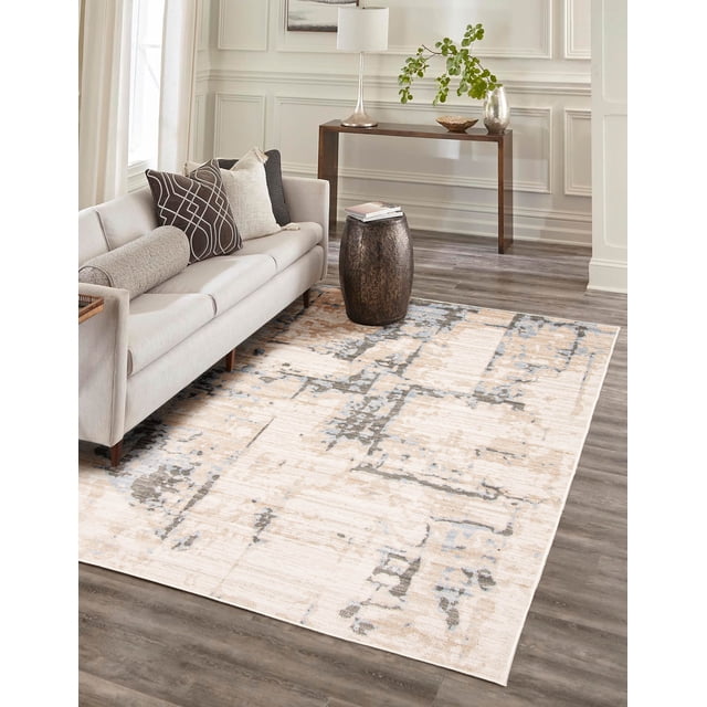 ECARPET Celeste Contemporary/Modern Area Rug with abstract beige and gray patterns on a light base, shown in a living room with a light gray sofa featuring geometric and solid pillows, a dark wood drum-shaped side table with books, and a slim console table with a lamp and greenery on wood flooring. Ideal for living rooms, bedrooms, or hallways.