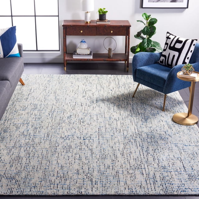 SAFAVIEH Tapis en Laine à Rayures Géométriques Delia Abstraites avec une Douce texture de Laine à Poil en Boucle et de Fines Rayures Géométriques Bleu et Crème, Exposé dans un Salon Contemporain entre un sofa Gris et un Fauteuil Bleu avec un Coussin Noir et Blanc, à Côté d'Une console en Bois et d'Une table d'Appoint Dorée, Convient pour Ajouter de la Chaleur et un Confort Décoratif.