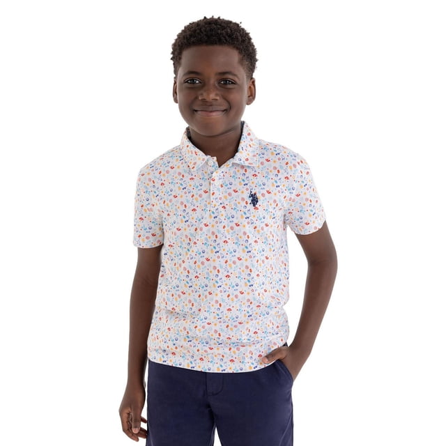 U.S. Polo Assn. Chemise Polo à Manches Courtes pour Garçon Play-formance en Blanc avec un Petit Imprimé floral et Géométrique Coloré, Comprenant un Col Rabattable, une Patte de Boutonnage avant à Deux Boutons et un logo U.S. Polo Assn. Brodé Bleu Marine sur la Poitrine Gauche, Assortie à des shorts Bleu Marine, Convient aux Tenues Décontractées Ou au Jeu Actif.
