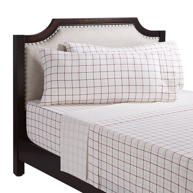 Double bed dressed in Holiday Time 4-piece holiday plaid flannel sheet set featuring a white base and red grid pattern on fitted sheet, flat sheet, and pillowcases.