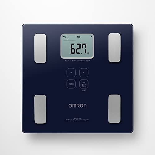 Omron Moniteur de Composition Corporelle HBF-236-JDB au design Épuré et Bleu Foncé avec un Profil Mince d'Environ 28 mm. le Moniteur Présente un Affichage Numérique Affichant le Poids en Kilogrammes, Ainsi Que Quatre Capteurs Métalliques pour l'Analyse de la Composition Corporelle. Il Comprend une Fonction d'Enjambement pour l'Activation Automatique de l'Alimentation et une Fonction de Reconnaissance Automatique pour l'Identification des Utilisateurs. la Langue de l'Interface Est en Japonais, et l'Appareil Est