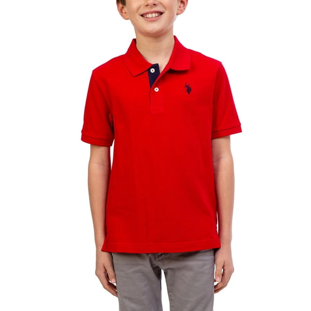 U.S. Polo Assn Chemise Polo à Manches Courtes pour Garçon en Rouge avec Col Rabattable, Patte Bleu Marine à Deux Boutons, logo Bleu Marine Brodé sur la Poitrine Gauche et Fentes Latérales à l'Ourlet, Montrée Orientée vers l'Avant Assortie à un Pantalon Gris, Idéale pour l'École Ou les Tenues Décontractées.
