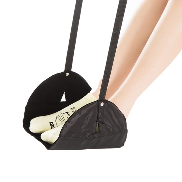 Travel Foot Rest Creative Lightweight Foot Hammock Desk Foot Rest for Airplane in black color. Made of durable polyester material, it measures 33x33cm (12.99x12.99in) with a strap length of 50cm (19.69in). Designed for use in offices, schools, buses, trains, and airplanes, it provides a comfortable resting position for feet. The image shows the foot hammock in use, supporting feet with socks, suspended by adjustable straps.