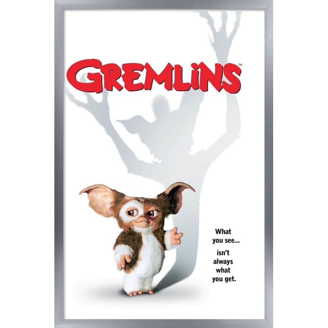 Gremlins - Affiche Murale sur une Feuille, 22,375 Po x 34 Po, Représentant une Petite Créature Duveteuse avec de Grandes Oreilles et un Ventre Blanc Debout sur un Fond Blanc Projetant une Grande Ombre avec des Bras Levés. le logo Gremlins Rouge Est en Haut, avec la phrase « Ce Que Vous Voyez... n'Est Pas Toujours Ce Que Vous Obtenez. » à Droite, Idéal pour la Déco Murale.
