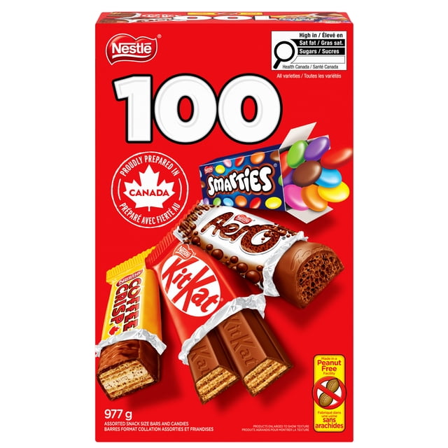 NESTLE KITKAT, AERO, SMARTIES, COFFEE CRISP Mini Bars & Bonbons Vue Frontale d'Une Boîte Ouverte Assortie Incluant 100 Mini Gaufrettes KITKAT Emballées Individuellement, des Morceaux de Chocolat Remplis de Bulles AERO, des Tablettes SMARTIES Colorées et des Barres COFFEE CRISP Minces Disposées pour des Gâteries d'Halloween sur une surface Blanche Unie; Souvent Utilisé pour des Bols de Bonbons pour Fête Ou pour la Cueillette de Bonbons.