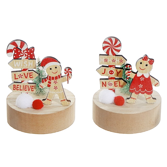 Gingerbread And Candycane On Wood Base Decor (Asstd) - Set of 6 featuring two wooden gingerbread figures on round wood bases; one in a red scarf and hat holding a candy cane with signposts reading 'Wish Love Believe', the other in a red dress with a bow holding a candy cane with signposts saying 'Joy Noel', both accented with mini pom-poms and a snowy bottlebrush tree, suitable for holiday decor and festive accents.