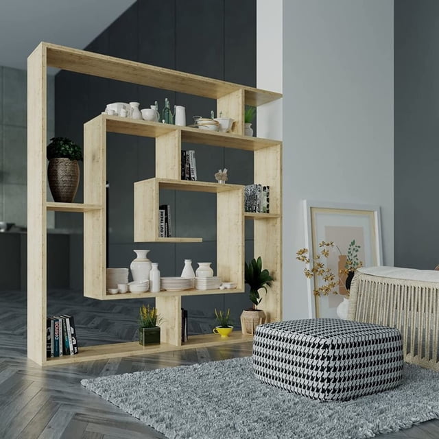 JV Home Labyrinth Collection 51x49 Inch Grand Bookcase in oak finish, featuring a stylish 6-tier shelving design with geometric patterns. This kids' bookcase is made from durable manufactured wood with a melamine coating, offering ample storage for books, decor, electronics, and houseplants. Ideal for kids' rooms, it combines functionality with modern aesthetics. Displayed in a contemporary living room setting with decorative items and books arranged on the shelves. Assembly required.