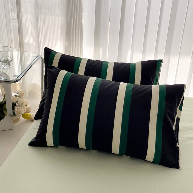 Tyidzon Pillow Protector Soft And Quiet Sateen Efficient Motes Resistance Pillowcase in army green with a striped design. Made of cotton, it measures approximately 18.89x29.13 inches and features a hem with piping and an envelope closure for secure fit. Displayed on a bed in a bright room with sheer curtains and a glass side table.