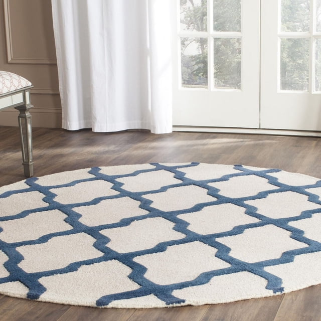Safavieh Cambridge Tapis Géométrique Liam, Rond avec pile de Laine Blanche Tuftée à la Main et Motif de Treillis Géométrique Bleu, Posé sur Plancher de Bois Franc Près des Rideaux Blancs et des Portes en Verre, Convient à la Déco Moderne de la Maison Ou du Bureau.
