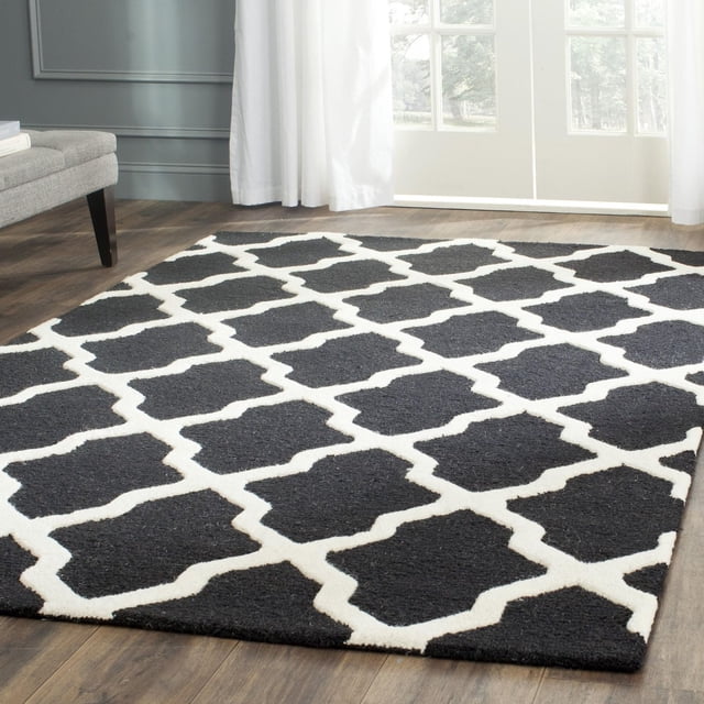 Safavieh Cambridge Tapis Géométrique Liam en Noir et Blanc avec Motif de Treillis en Laine Tufté à la Main, Coupe Peluche et Velours Texturé à Boucles Haut/bas, Exposé sur Plancher de Bois Franc Près d'Un sofa Gris et de Rideaux Blancs, Idéal pour une Déco d'Accent Moderne à la Maison Ou au Bureau.