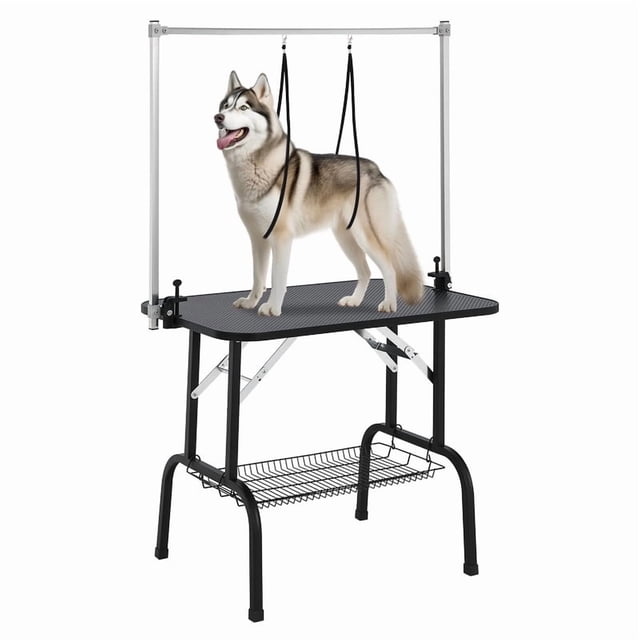 36-inch foldable pet grooming table with height-adjustable arms, noose, and mesh tray, designed for trimming and drying dogs at home. Features a durable stainless steel frame, non-slip surface, and 330 lbs static weight capacity. A large dog is secured on the table with safety straps.