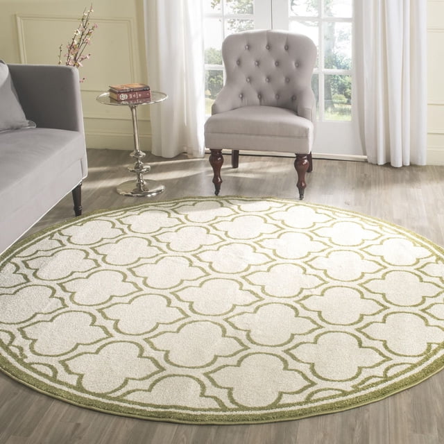 Safavieh Amherst Wilson Tapis Géométrique, Rond avec Fond Crème et Motif Géométrique Vert olive à Poil Coupé, sur Plancher de Bois Clair dans une Pièce Lumineuse avec un sofa Gris, table d'Appoint Argentée Tenant un Livre, et Chaise Rembourrée beige avec Pattes en Bois Près de Rideaux Blancs et de Portes en Verre, Idéal pour les Espaces Intérieurs Ou Extérieurs à Fort Achalandage.