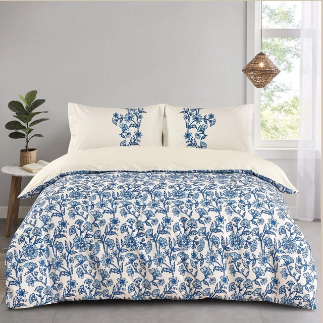 Johnson Home 5-Piece Comforter Set with 200TC breathable cotton featuring a blue floral pattern on white comforter and shams, displayed on a bed in a bright, minimalist room with a plant, side table, and woven pendant light, ideal for all-season comfort.