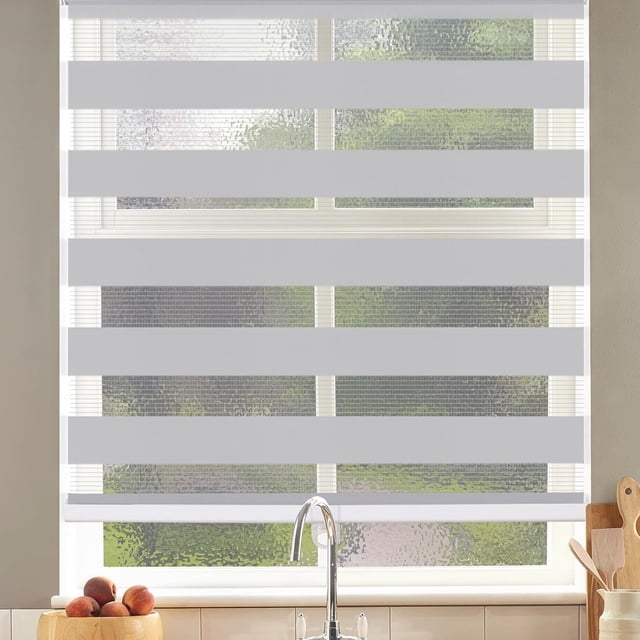 LUCKUP Cordless Zebra Blinds Roller shades for window, featuring a dual-layer design with sheer and solid grey polyester fabric for light filtering and privacy control. The blinds measure 21 inches wide by 72 inches high and include a cordless free-stop system for smooth height adjustment. Shown installed in a kitchen setting, the blinds have horizontal stripes and an aluminum bottom rail for added stability and durability.