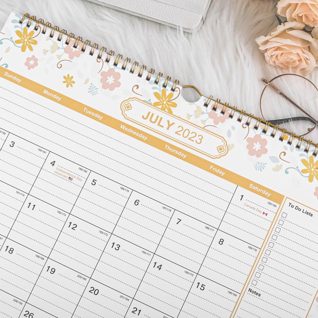 Tredstone 2024 Calendrier Planificateur Durable Calendrier Suspendu pour Tous les Jours Calendrier Mural 2024 pour Planificateur. l'Image Montre un Gros Plan de la page de Juillet 2023 du Calendrier avec un Motif floral en Haut et une Reliure en Spirale Dorée. le Calendrier Présente une Grille Inscriptible pour la Planification Quotidienne, des Listes de Choses à Faire et des notes. Il Est Fait de Papier extra Épais, Résistant aux Rayures et aux Déchirures, Assurant la Durabilité. Convient à la Maison, au Bureau Ou à l'Accrochage Mural, Il